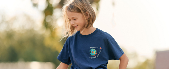 Abbildung zeigt Mädchen in einem blauen Jugendrotkreuz T-Shirt 