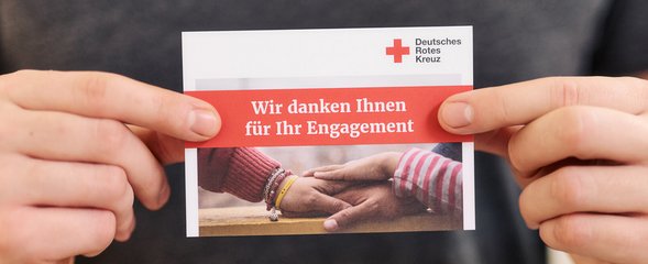Abbildung zeigt eine Person mit einer Karte des DRK