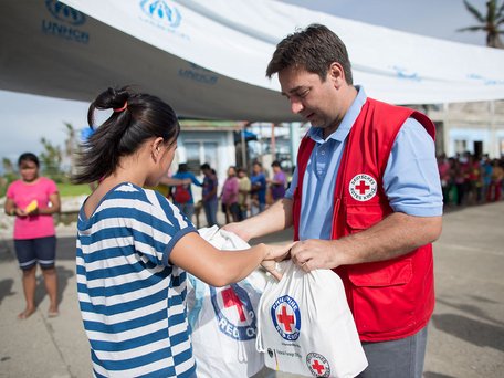 Abbildung eines Bildes der Pressereise des DRK auf die Philippinen nach dem Taifun Haiyan:  Verteilung von Hilfsgütern durch das Philippinische Rote Kreuz und das DRK in Dulag.