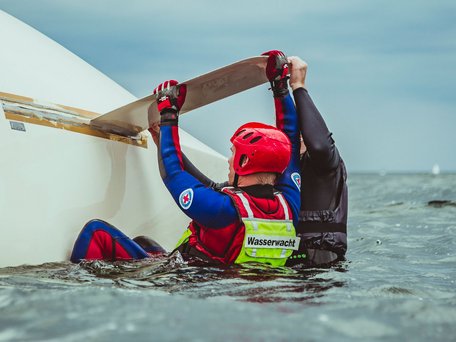Wasserwacht an der Ostsee in Mecklenburg-Vorpommern: Helfer und Segler beim Aufrichten eines gekenterten