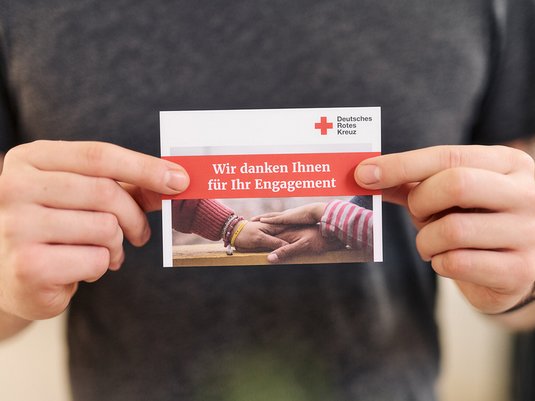 Abbildung zeigt Person mit einer Karte des DRK